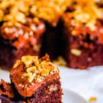 Slice of chocolate walnut cake on a white plate.