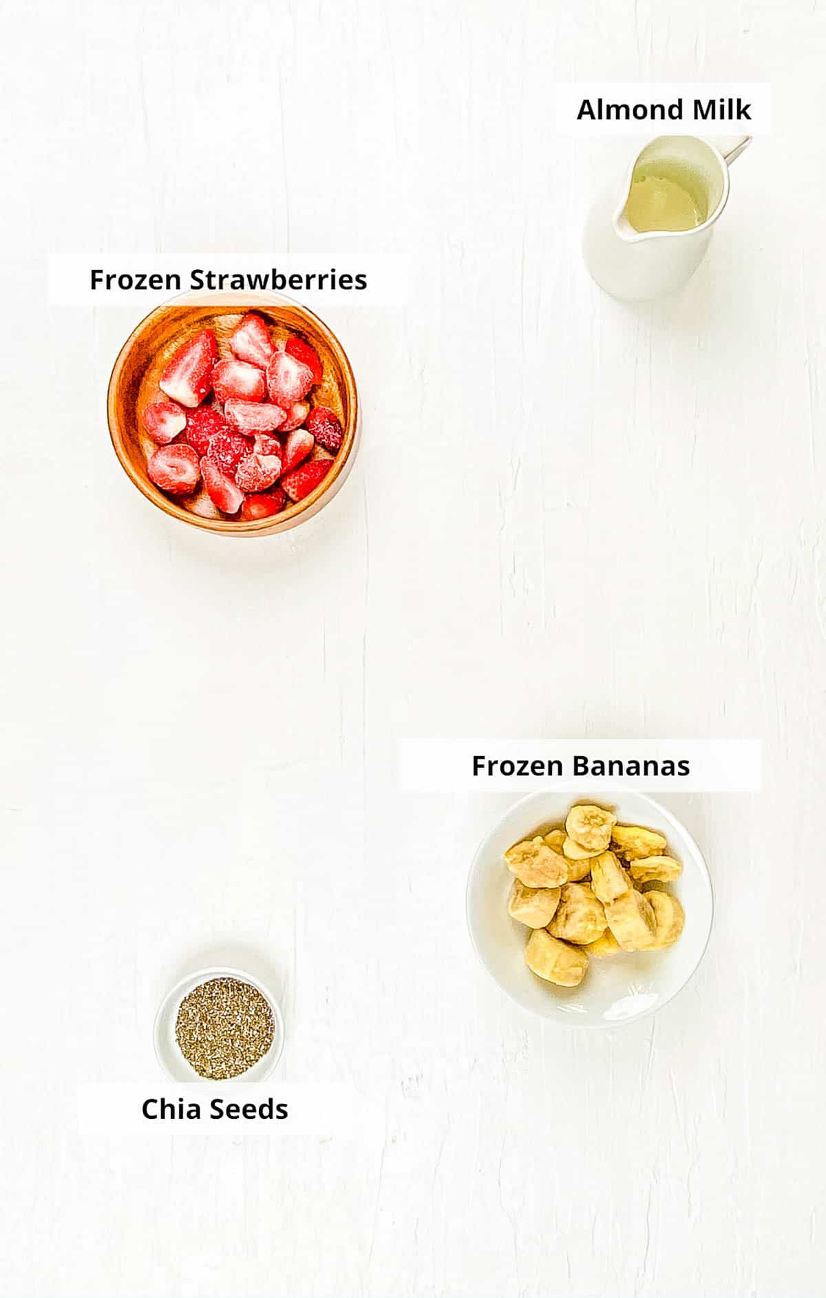 Ingredients for healthy strawberry smoothie bowl recipe on a white background.