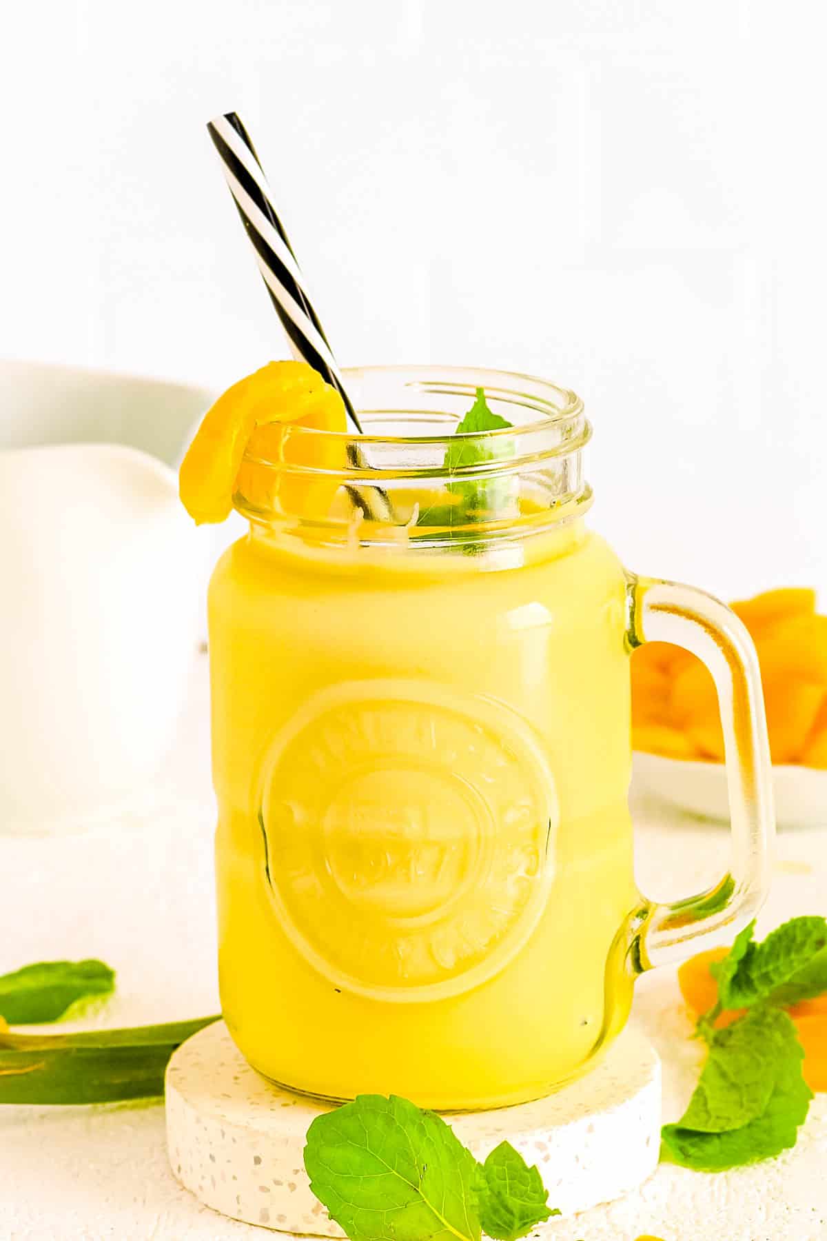 Jackfruit smoothie in a glass jar with a straw.