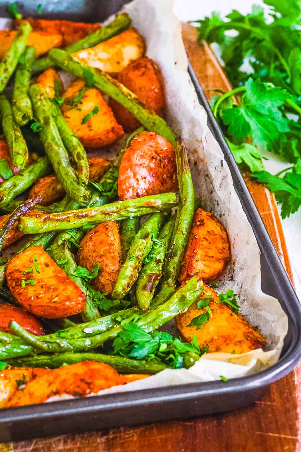Oven roasted green beans and potatoes on a sheet pan.
