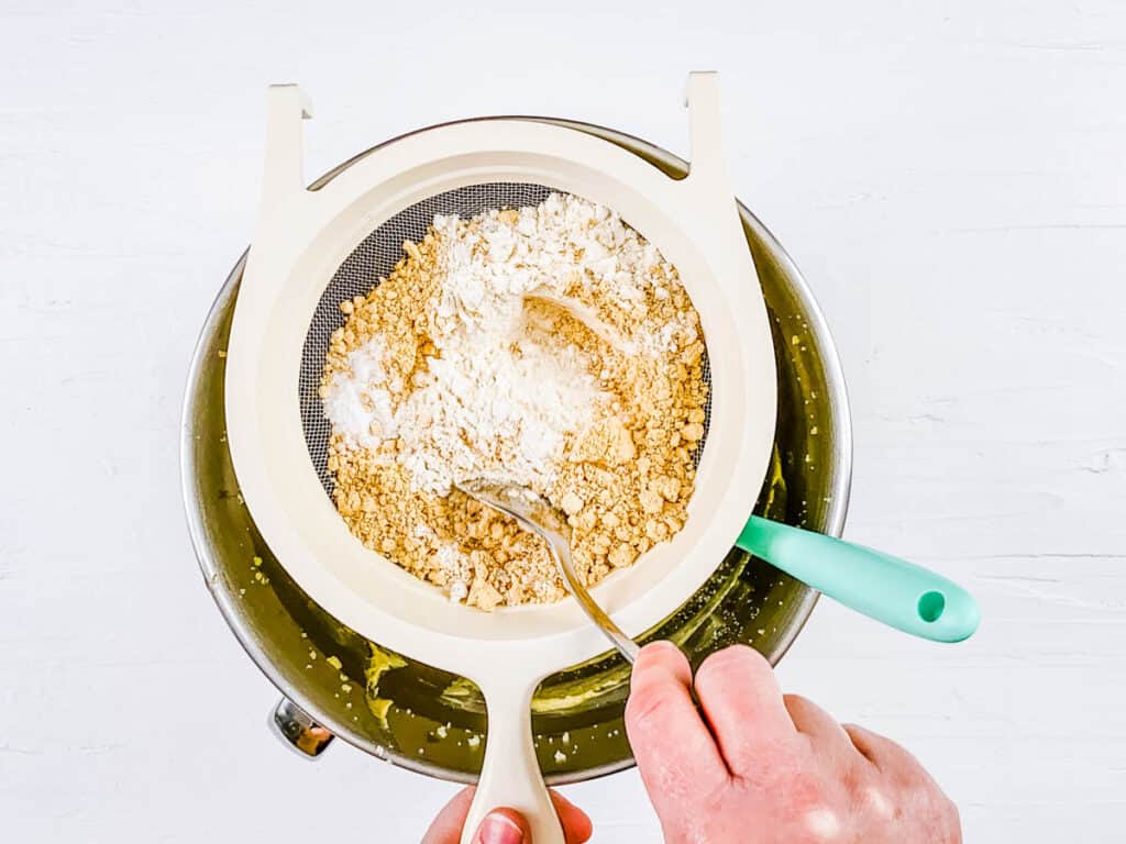 Flour and other dry ingredients for pb cookies sifted into a mixing bowl.