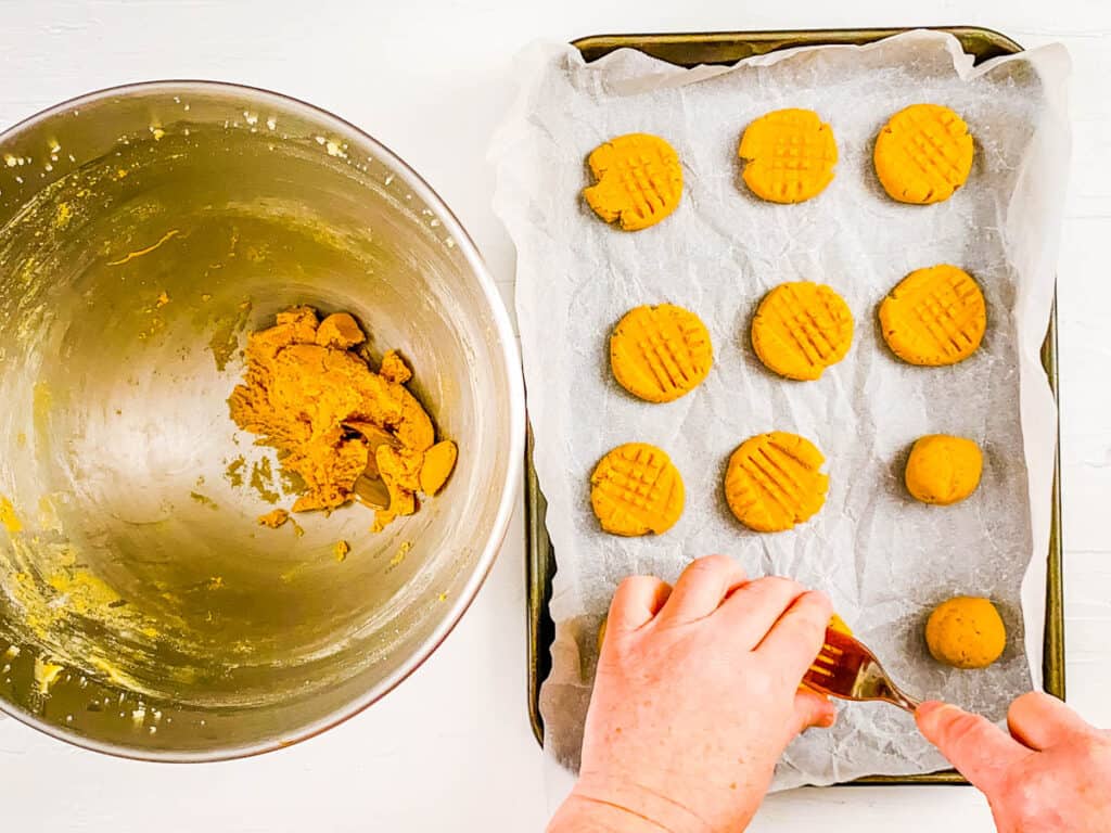 PB powder cookies pressed with a fork on a baking sheet.