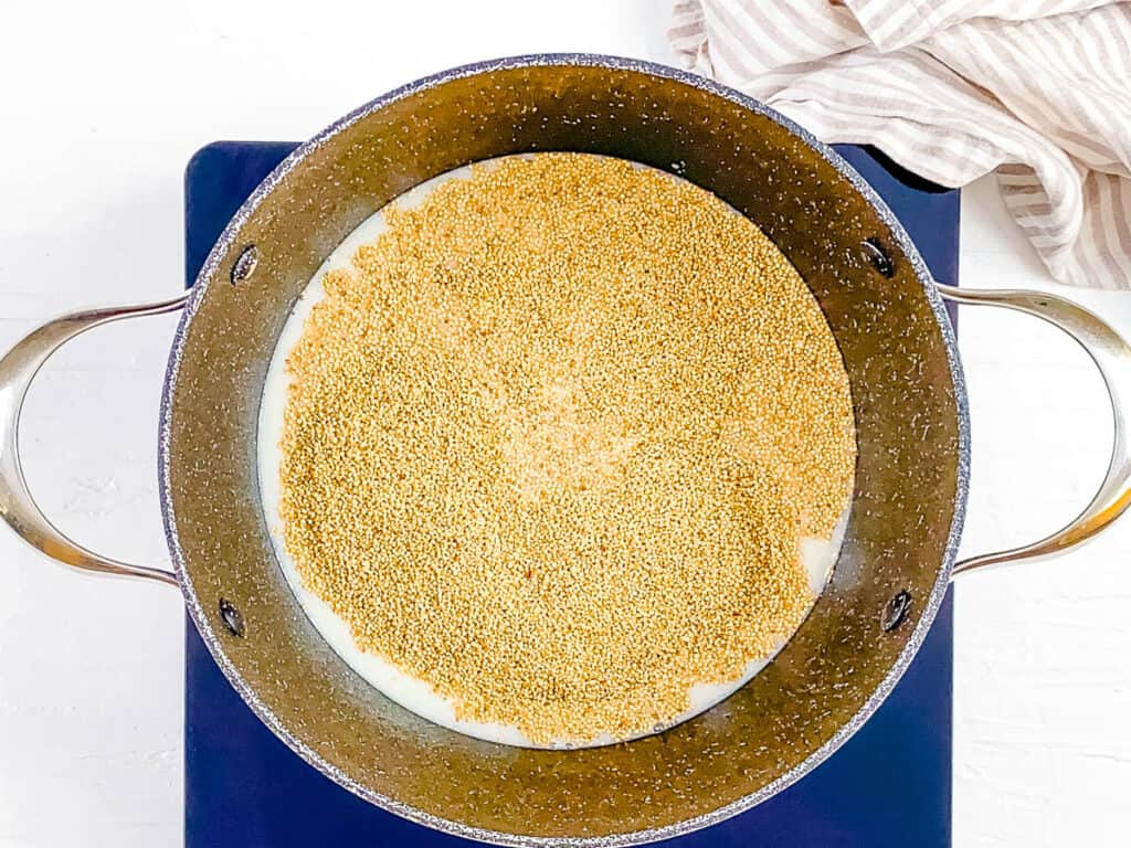 Quinoa cooking in a pot with water and milk.