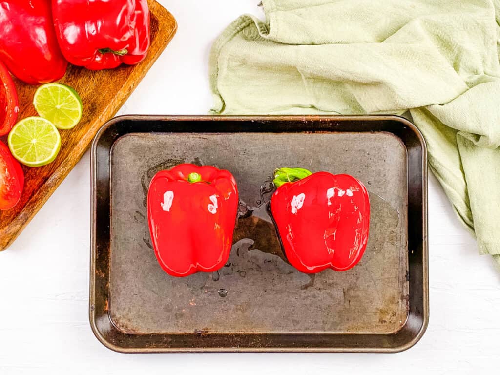Two bell peppers on a baking sheet.