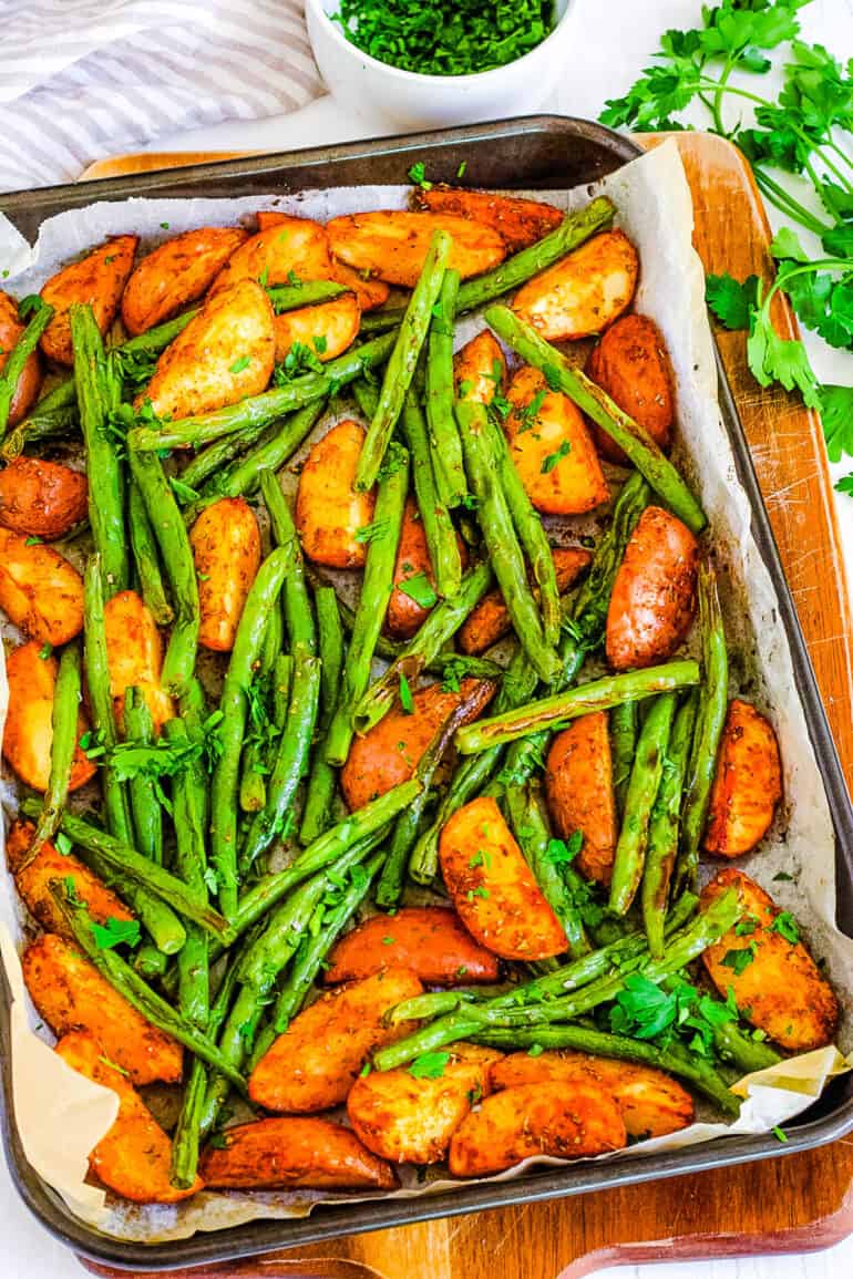 Oven roasted green beans and potatoes on a sheet pan.