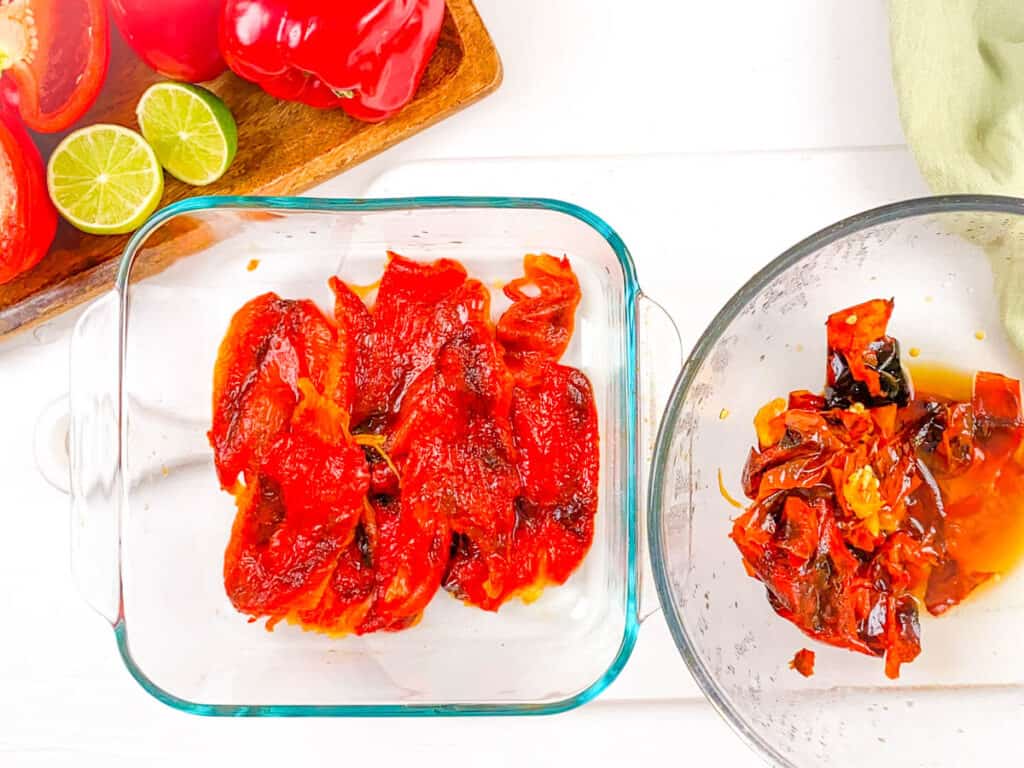 Skinned roasted bell peppers in a glass baking dish.