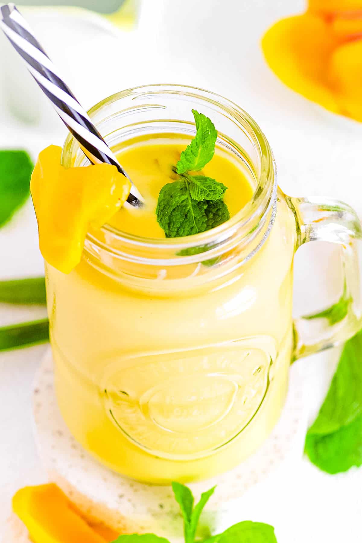 Jackfruit smoothie in a glass jar with a straw.