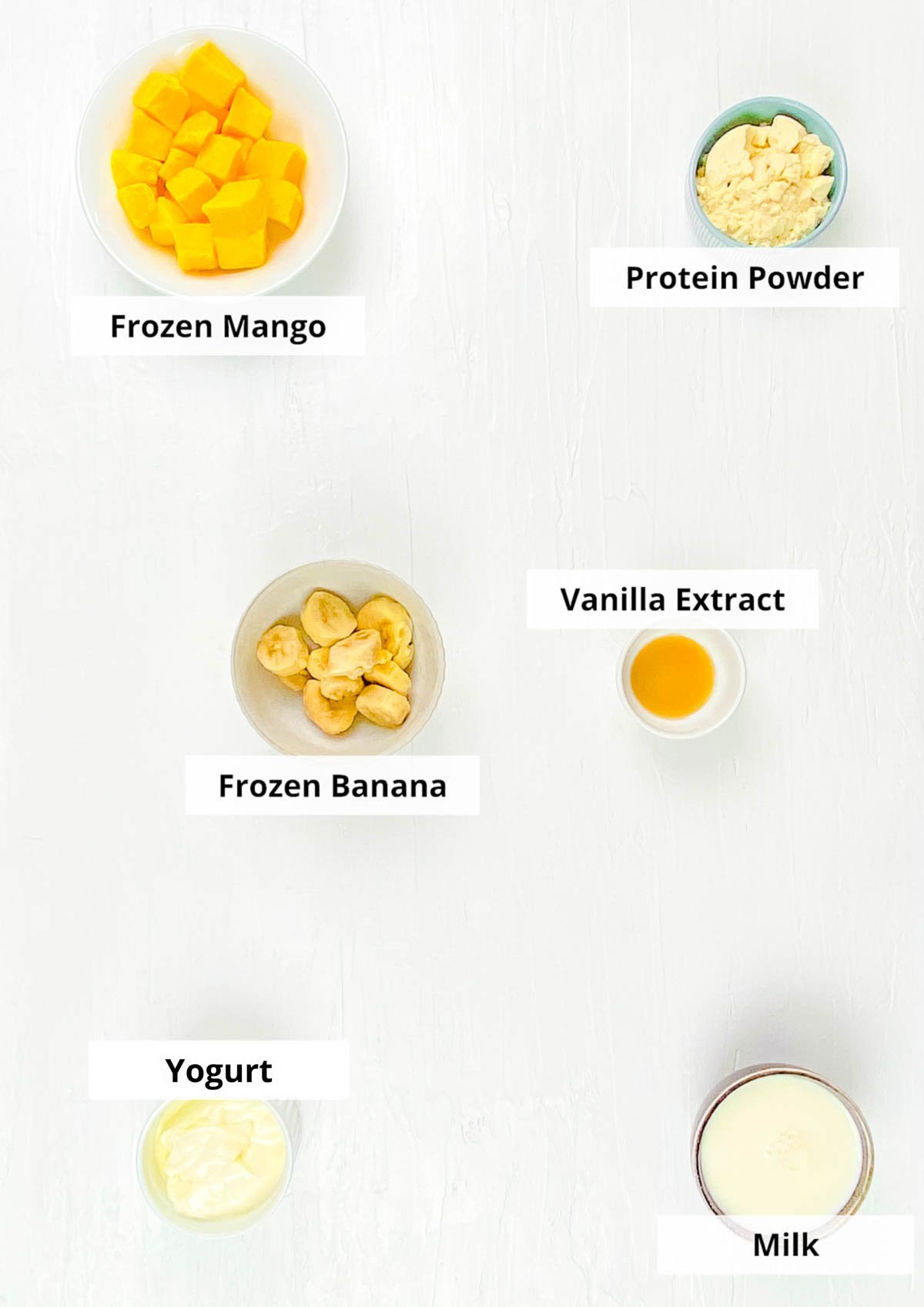 Ingredients for easy mango protein smoothie on a white background