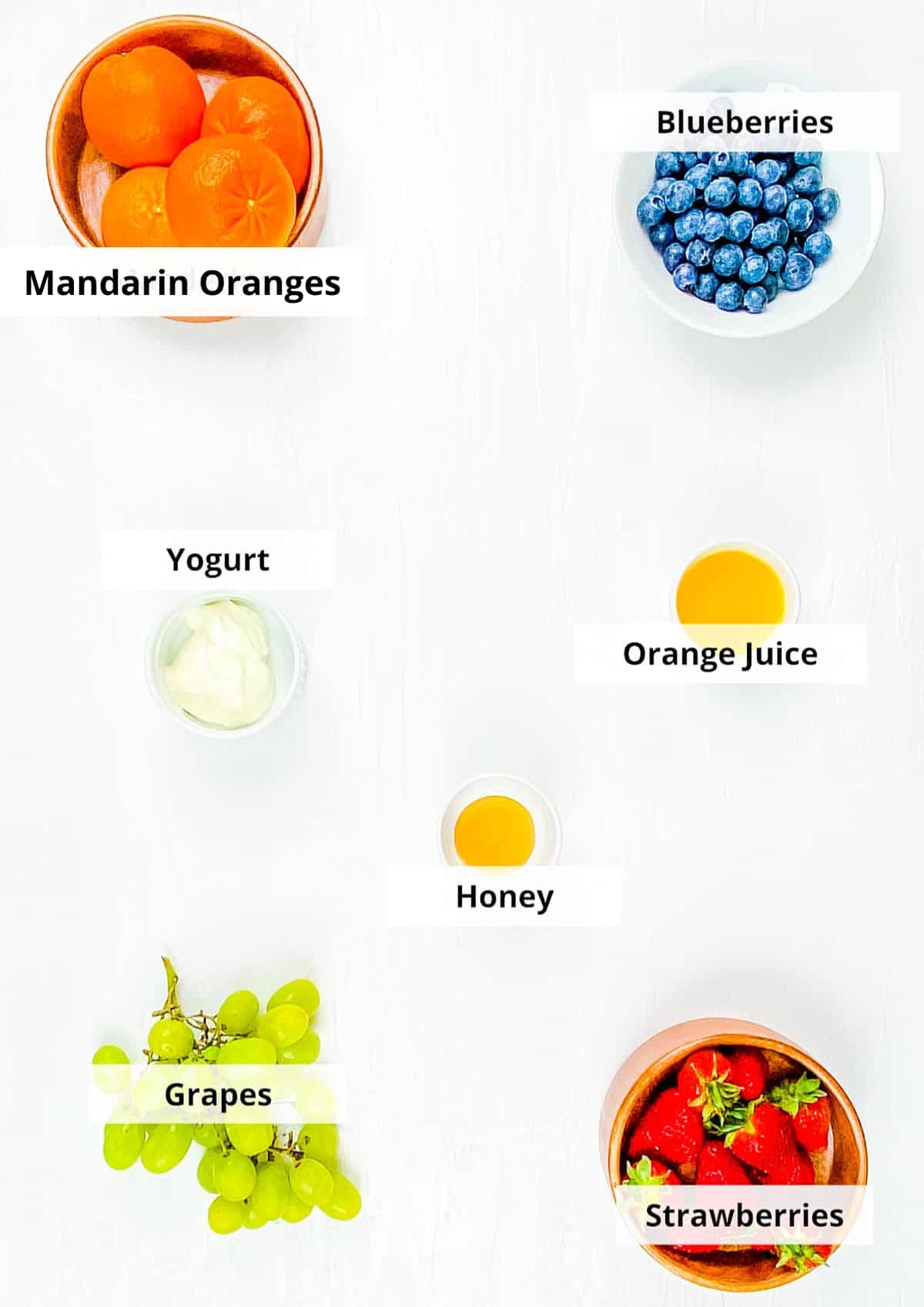 Ingrediënten voor gezond ontbijt fruitsalade recept op een witte achtergrond.