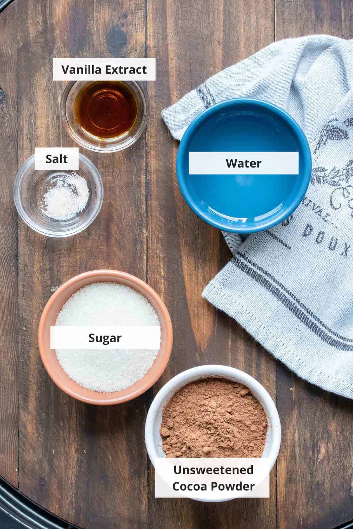 Ingredients for vegan chocolate sauce recipe on a wood background.