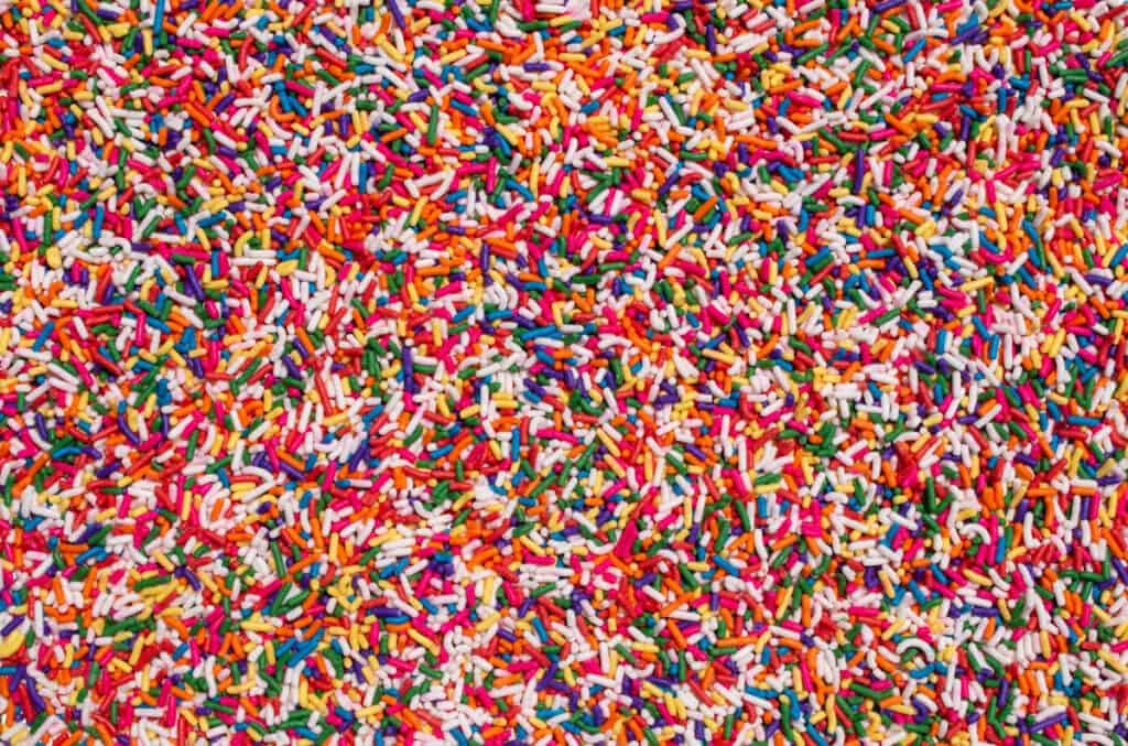 Big clear display of sprinkles candy party cake treats cover food decorations background.