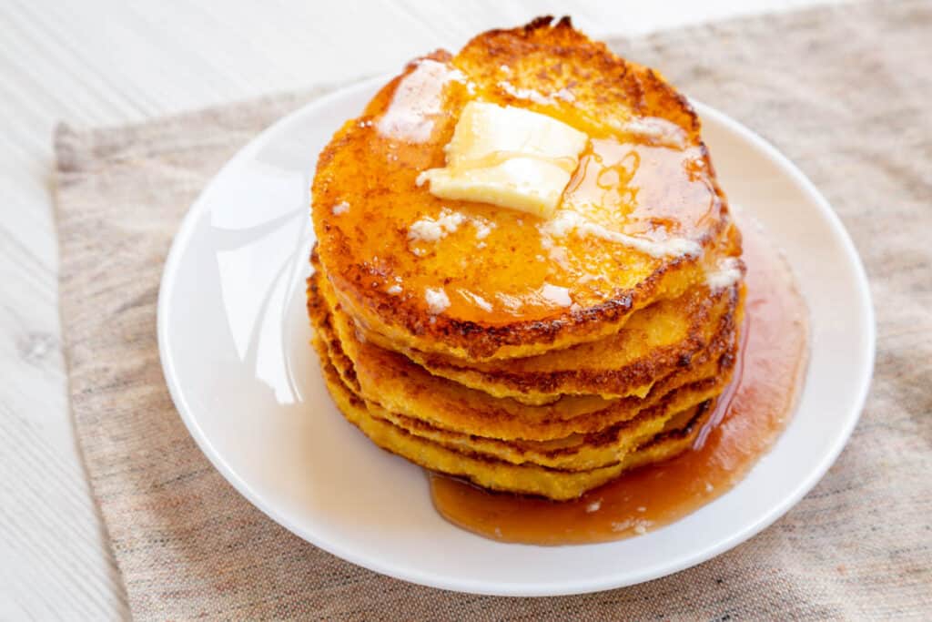 Homemade corn meal Johnny cakes on a white plate.