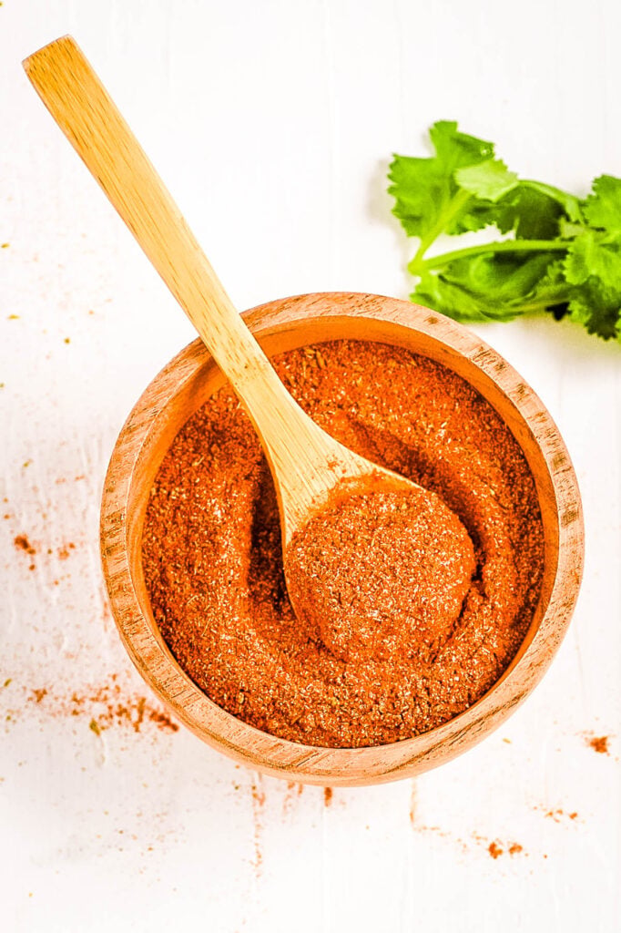 Old el paso taco seasoning recipe in a wooden bowl with a spoon.