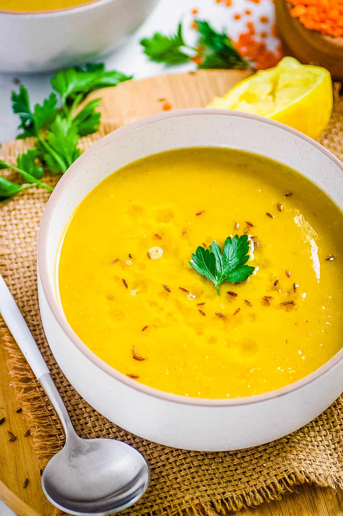 Traditional Lebanese lentil soup served in a white bowl, garnished with parsley.