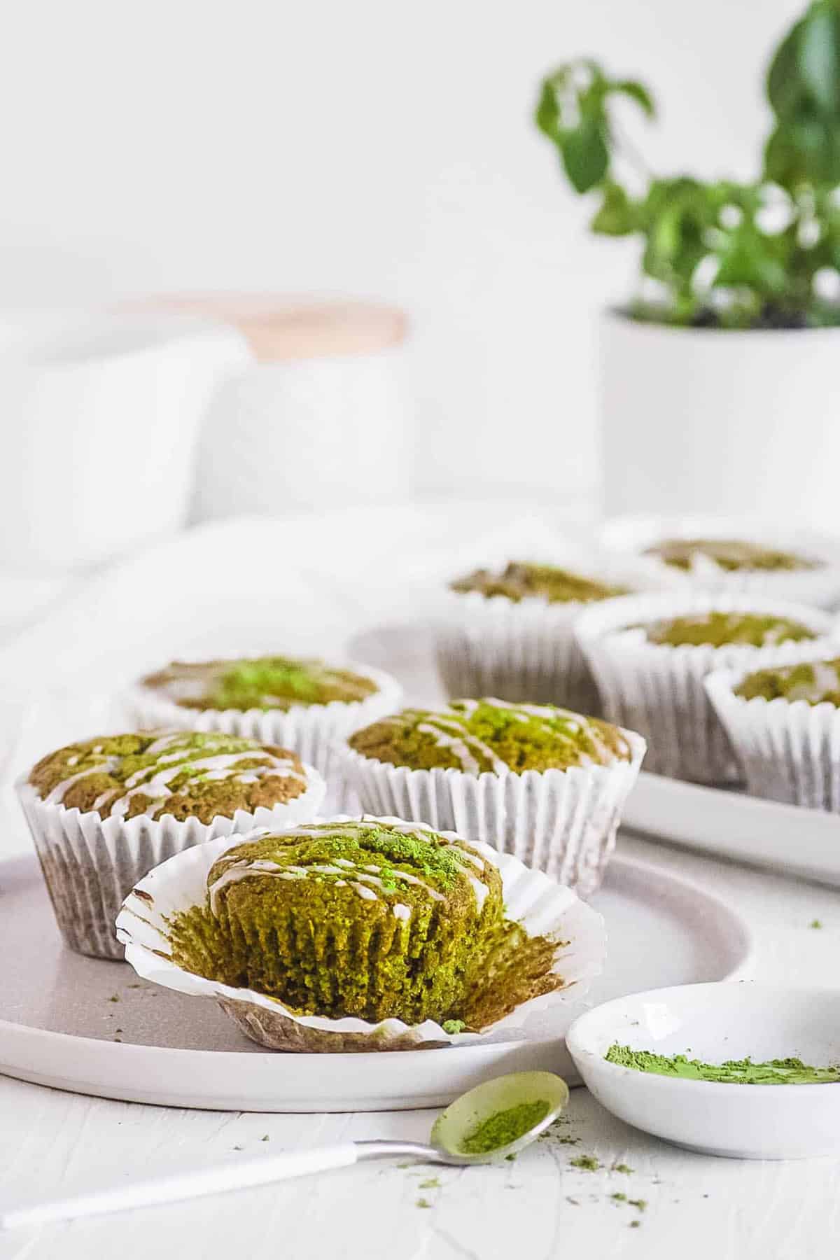 Easy vegan matcha muffins recipe on a white plate with lemon frosting.