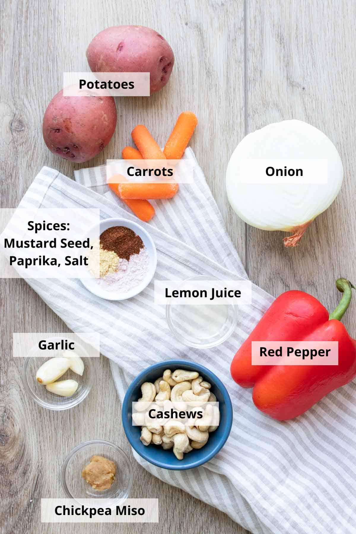 Ingredients for vegan cheese sauce without nutritional yeast on a wooden board.