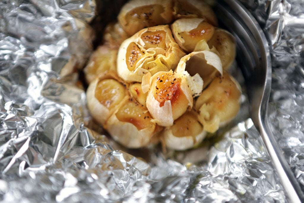 Clove of ،ic garlic wrapped in tin foil and roasted in olive oil and ،es.