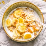 Homemade bananas and cream oatmeal in a bowl, topped with milk.