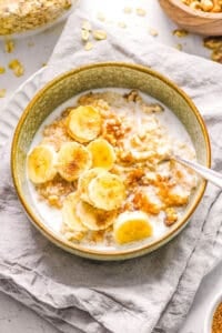 Homemade bananas and cream oatmeal in a bowl, topped with milk.
