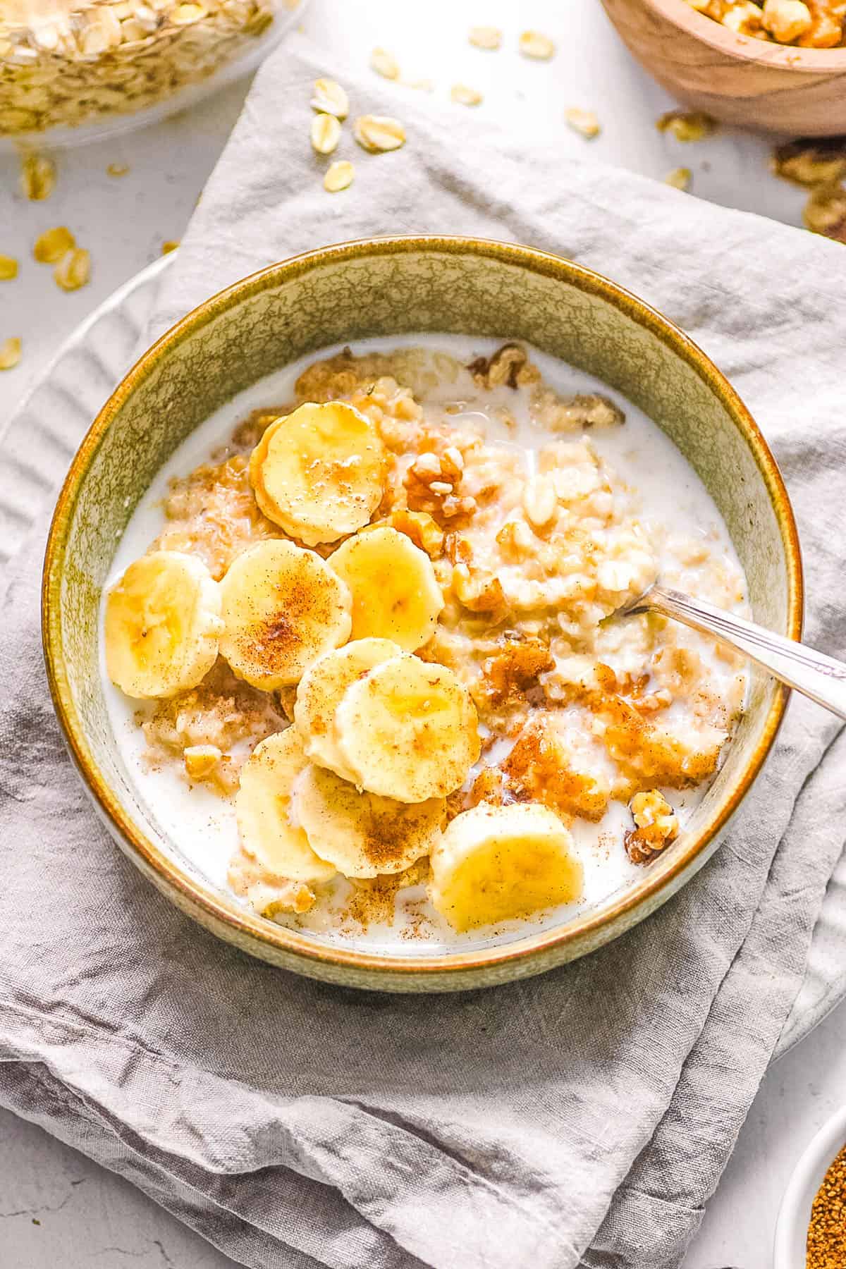 Homemade bananas and cream oatmeal in a bowl, topped with milk.