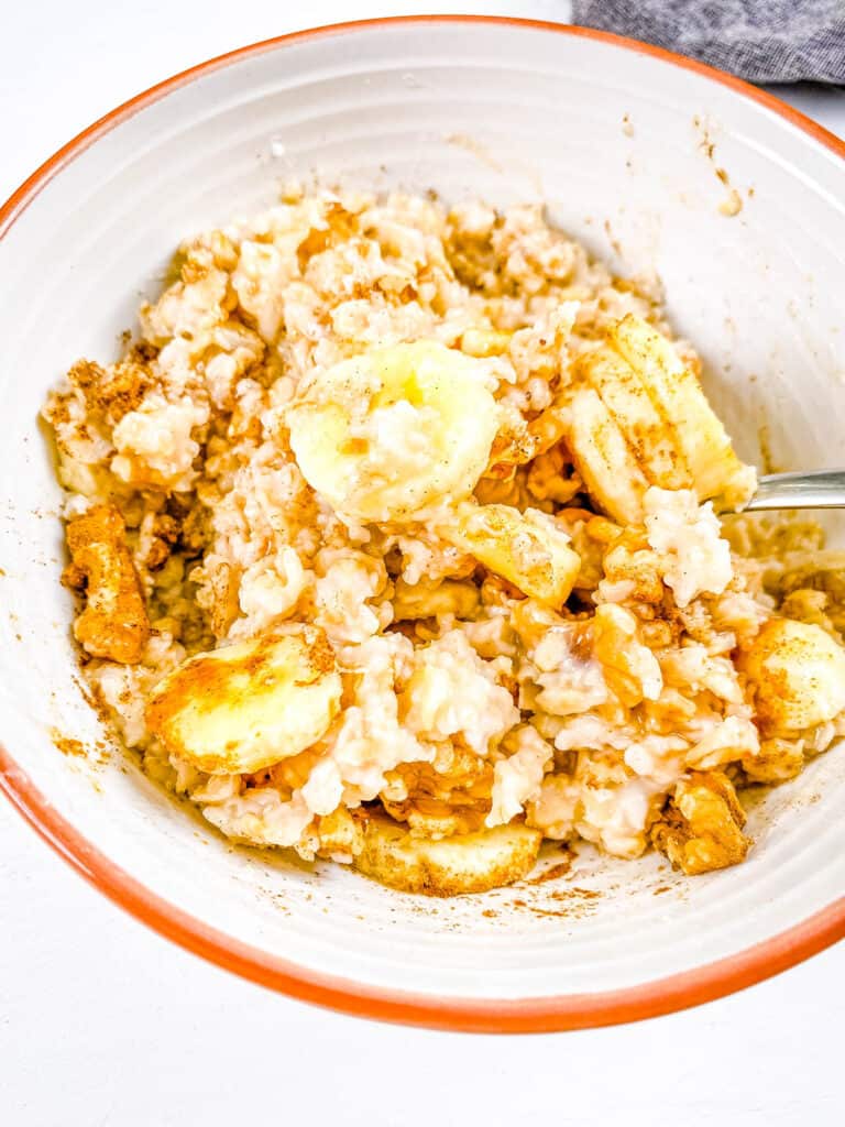 Easy banana bread oatmeal in a white bowl with a s،.