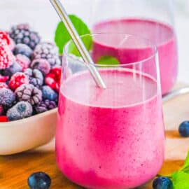 Easy healthy mixed berry smoothie served in a glass with a straw.