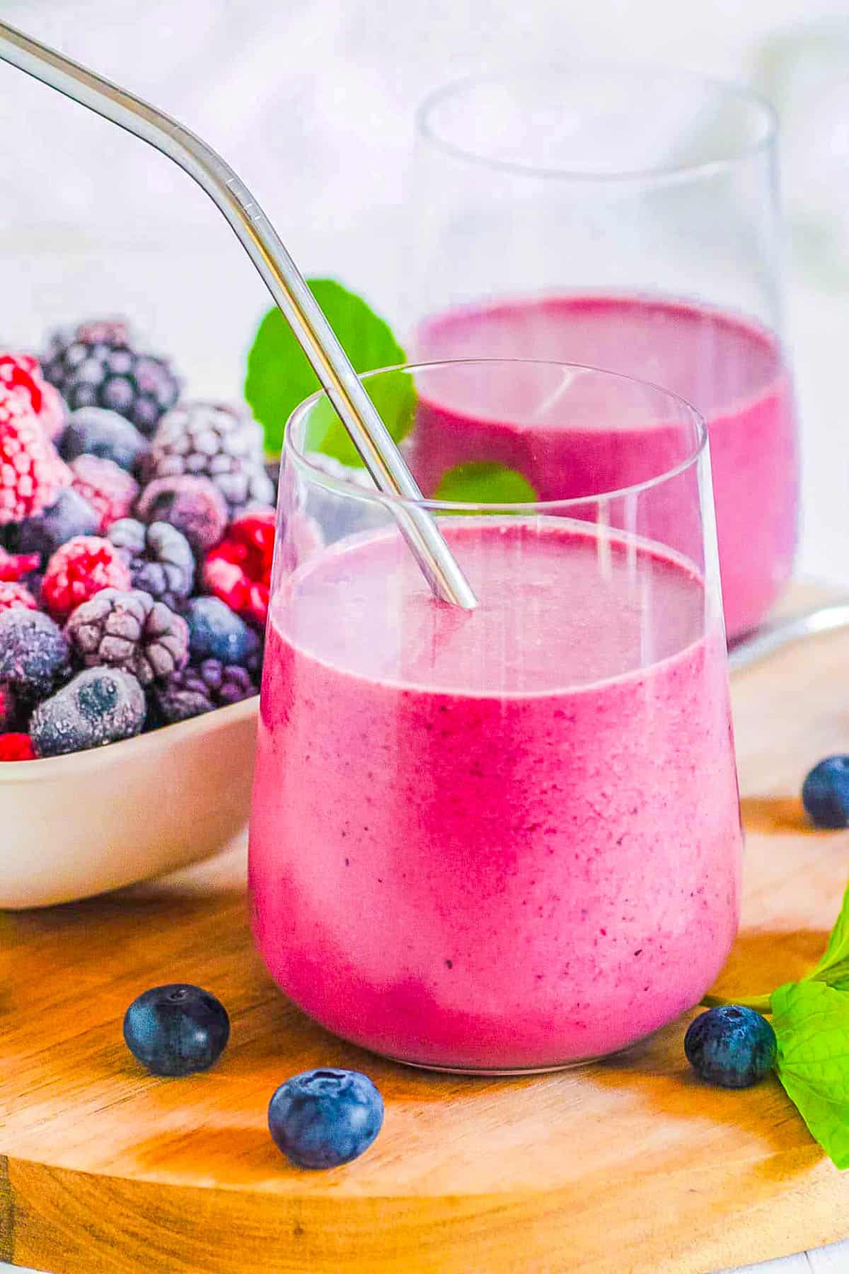 Easy healthy mixed berry smoothie served in a glass with a straw.