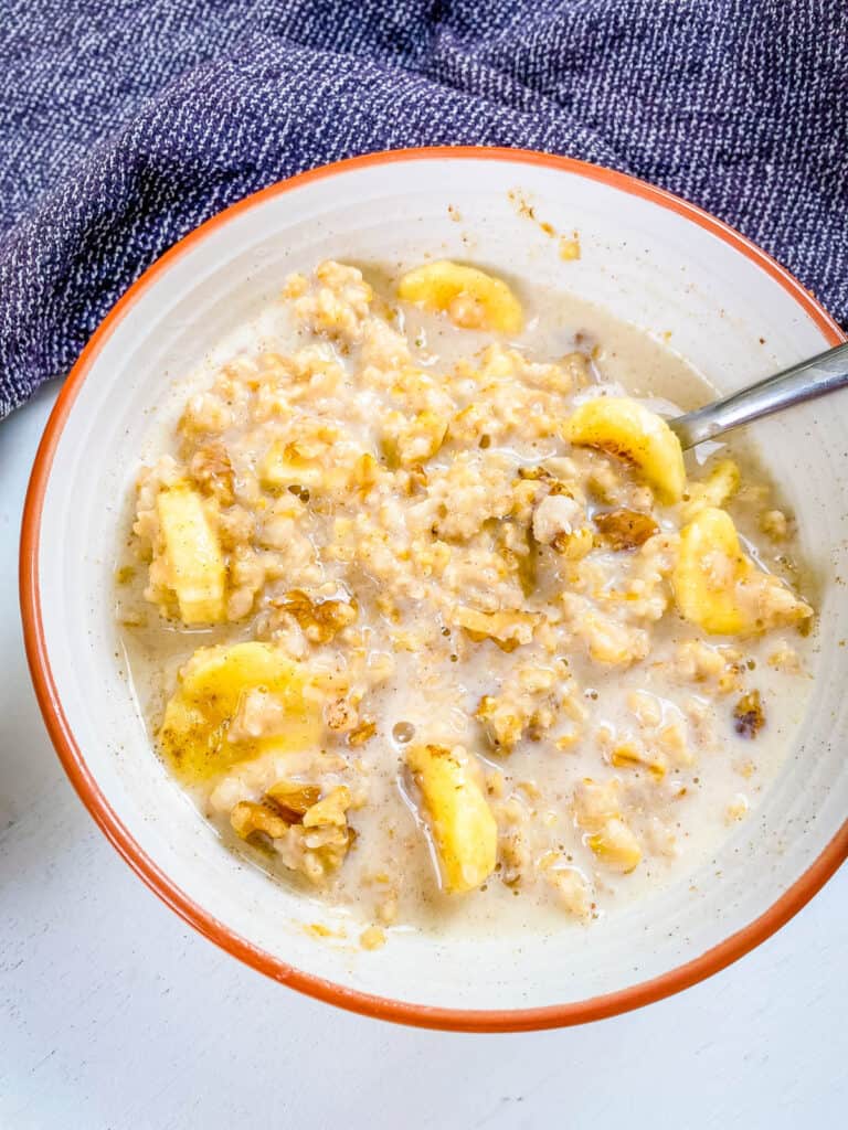 Homemade banana oatmeal in a white bowl with a spoon.