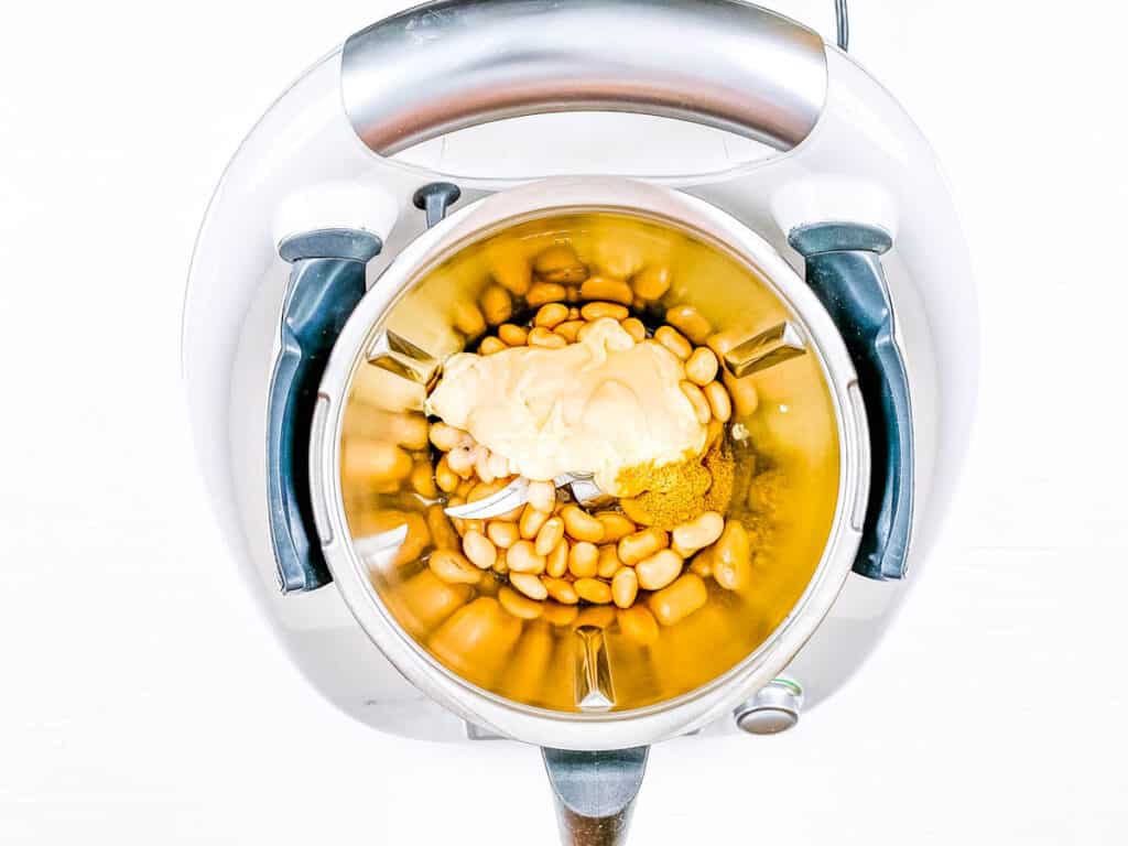 Haricots et tahini et épices dans un robot culinaire.