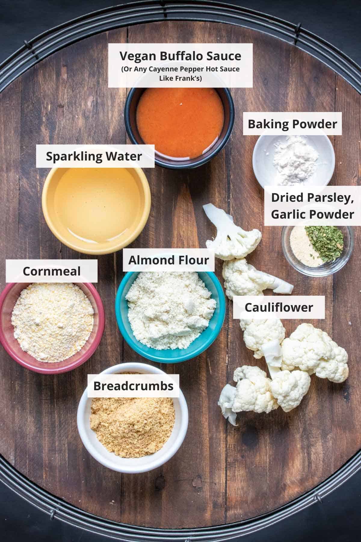 Ingredients for vegan buffalo cauliflower wings on a wood background.