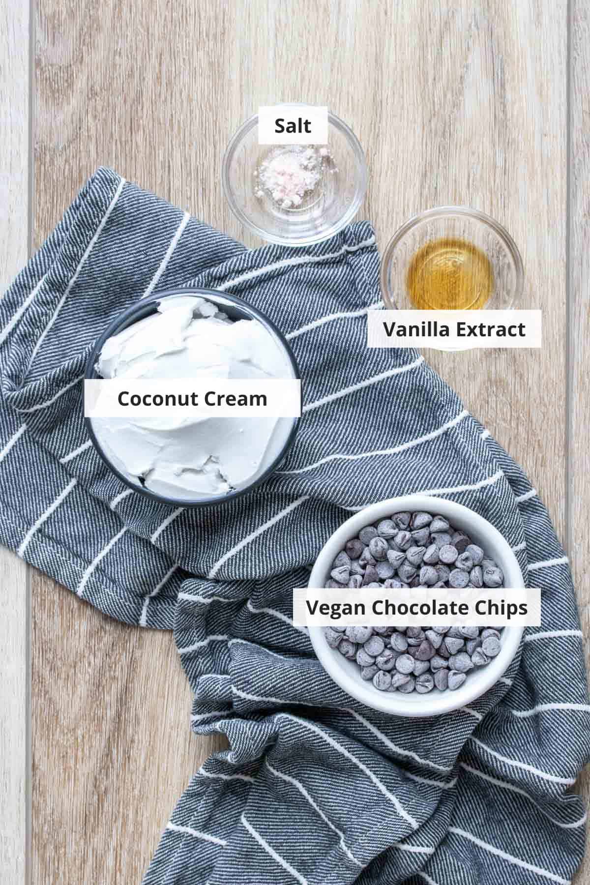 Ingredients for vegan chocolate ganache on a wood background.