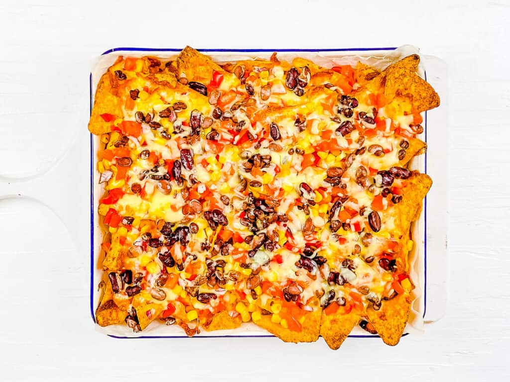 Veggie meatless loaded nachos on a baking sheet.