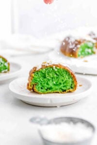 Vietnamese pandan honeycomb cake cut to show green pandan inside, served on a white plate.