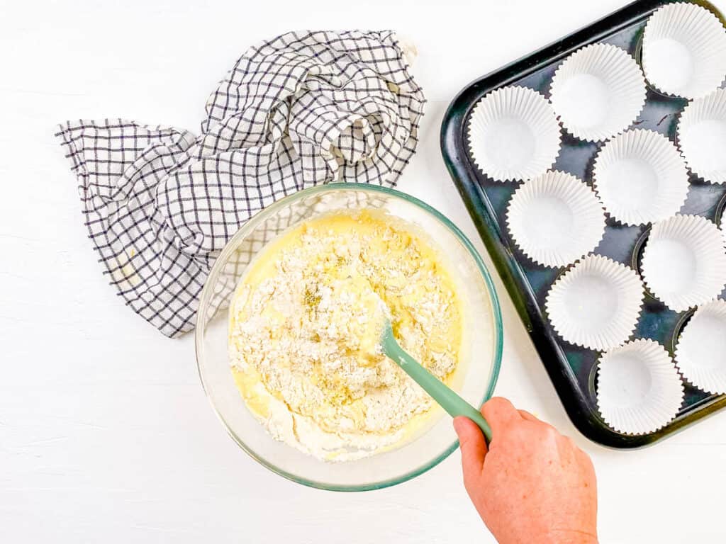 Wet and dry ingredients for muffins combined in a mixing bowl.