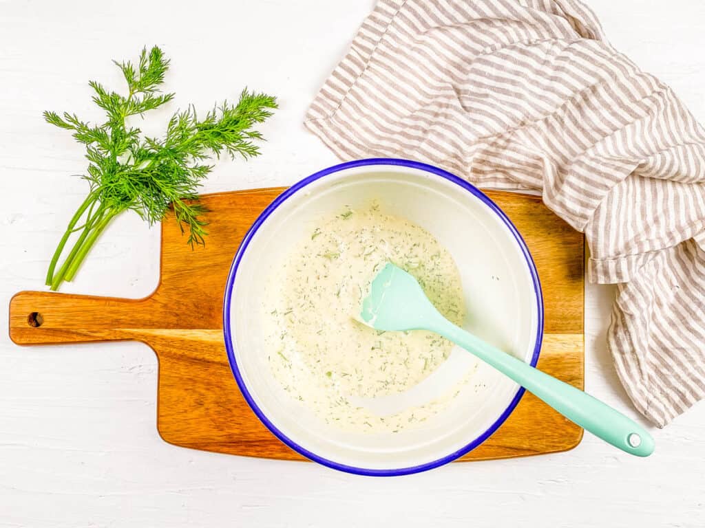 Mustard potato salad dressing in a mixing bowl.