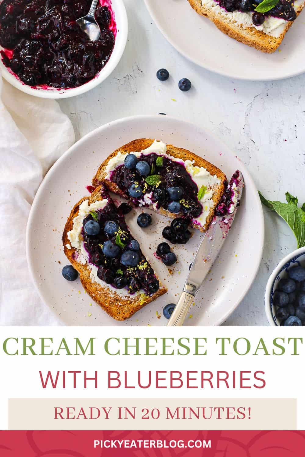 Toast de fromage à la crème aux bleuets garni de menthe fraîche, servi sur une assiette blanche.