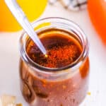 Gluten free stir fry sauce stored in a glass jar with a spoon.