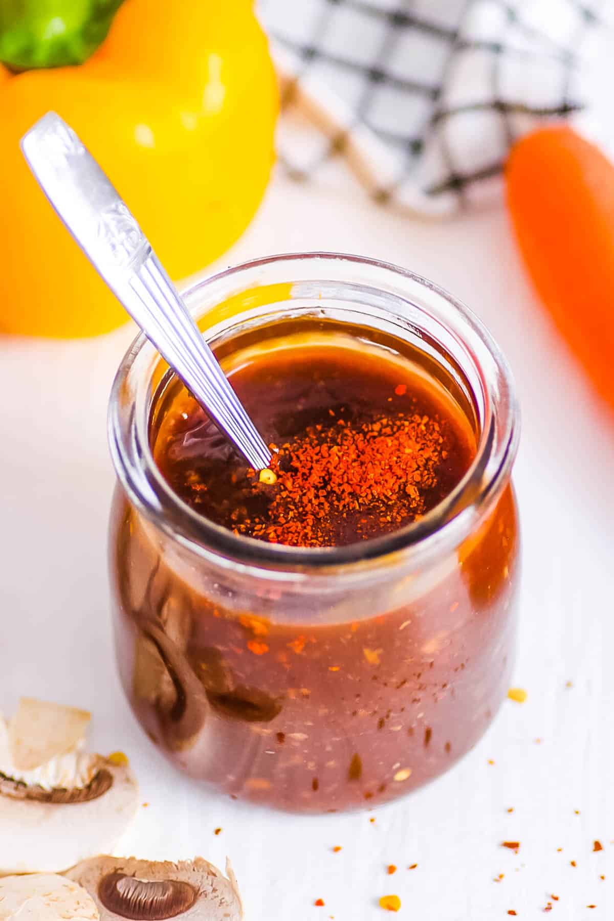 Gluten free stir fry sauce stored in a glass jar with a spoon.