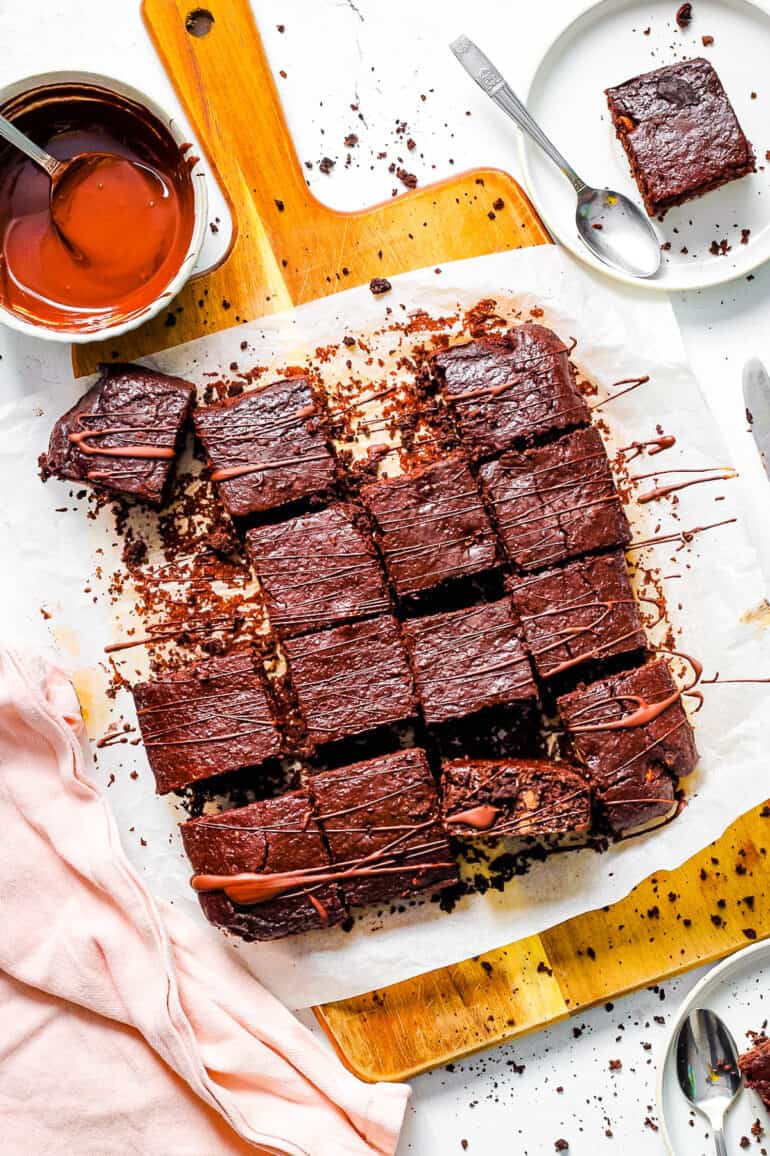Healthy lactation brownies on parchment paper, drizzled with chocolate.