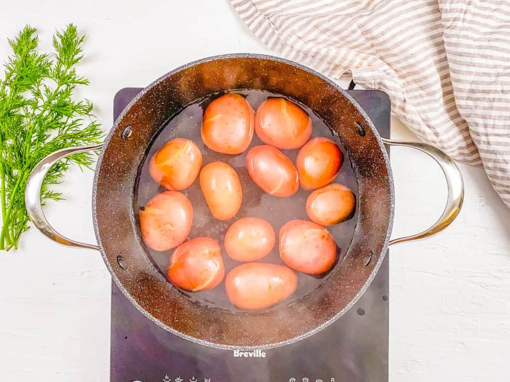 Cooked red potatoes in a stock pot on the burner.