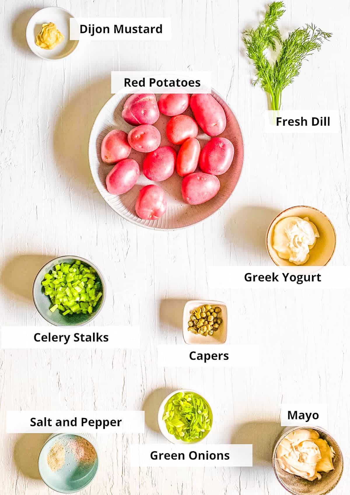 All of the ingredients for potato salad without eggs recipe on a white background.