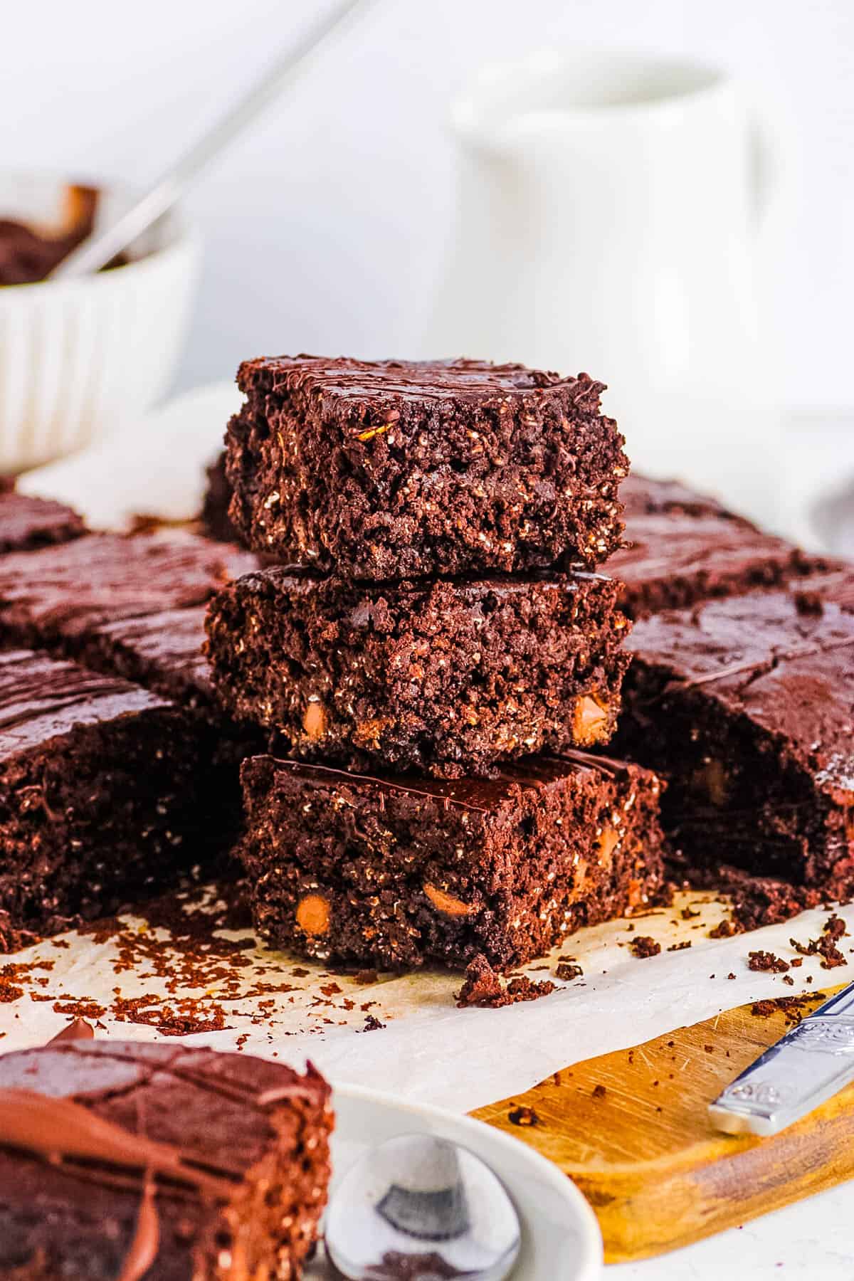 Vegan and gluten free lactation brownies stacked on a sheet of parchment paper.