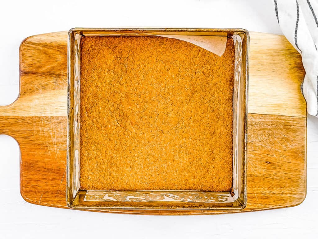 Graham cracker crust baked in a baking dish.