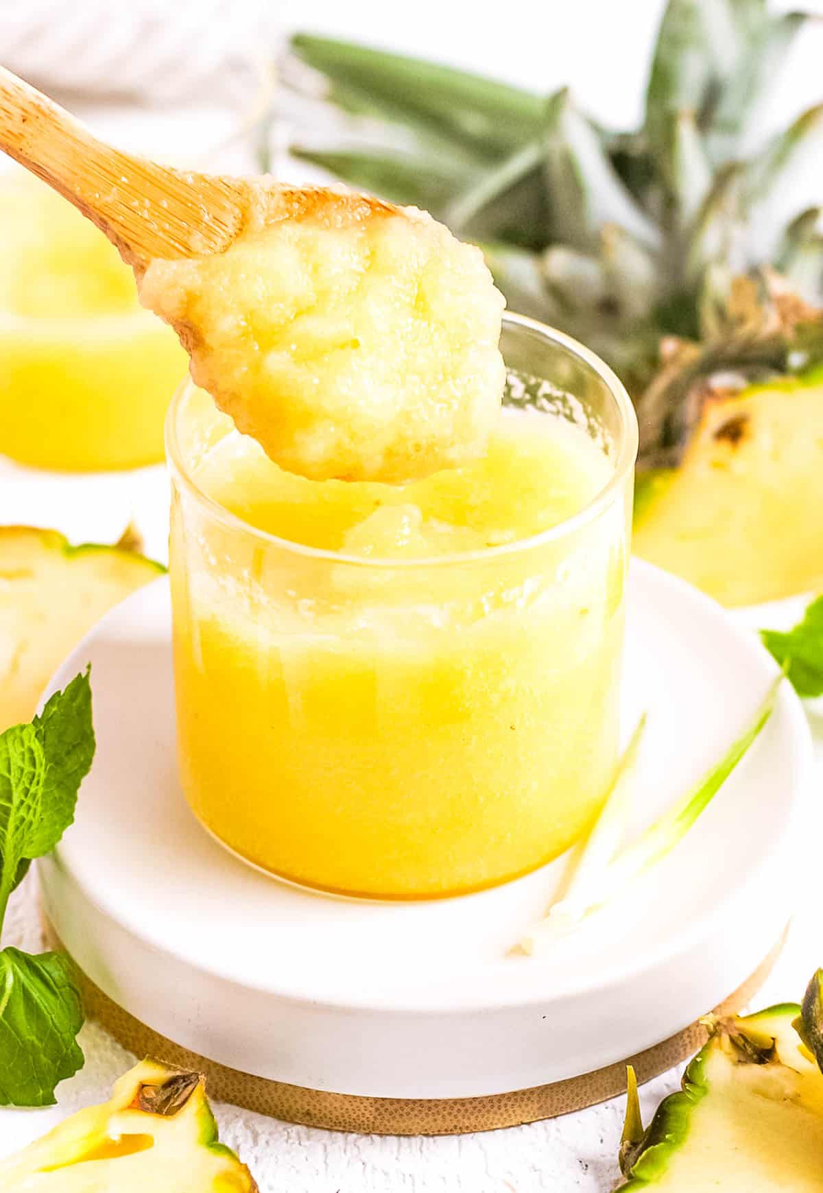 Pineapple puree served in a glass jar with a wooden spoon.