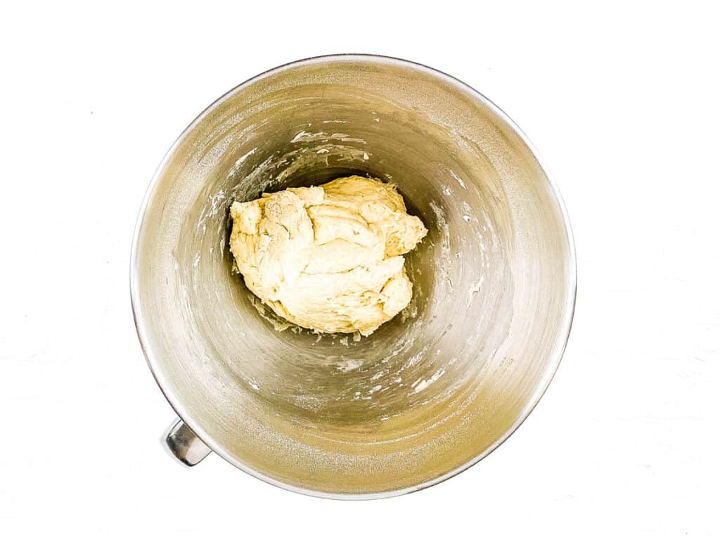 Croissant dough being mixed in a stand mixer.