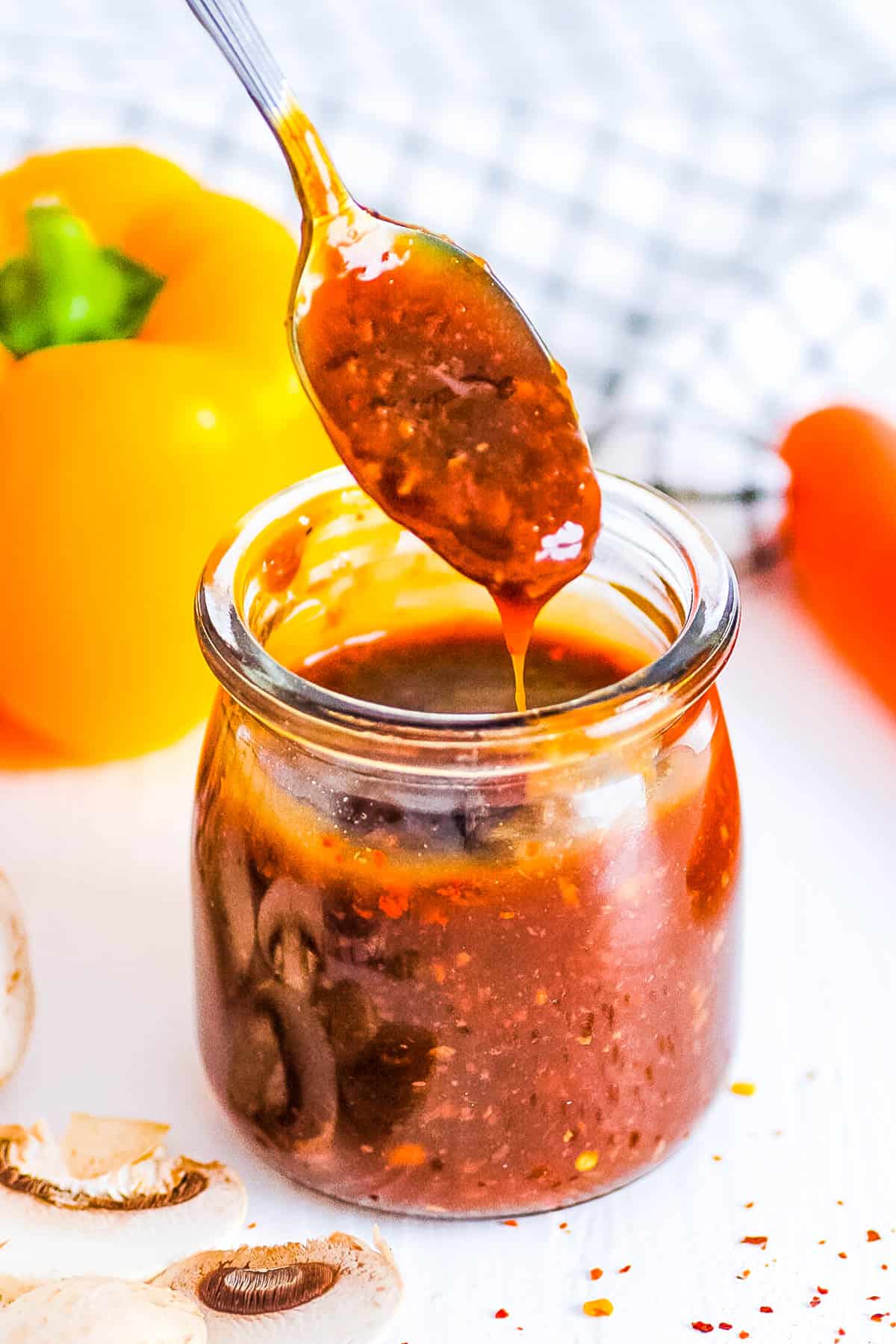 Gluten free stir fry sauce stored in a glass jar with a spoon.