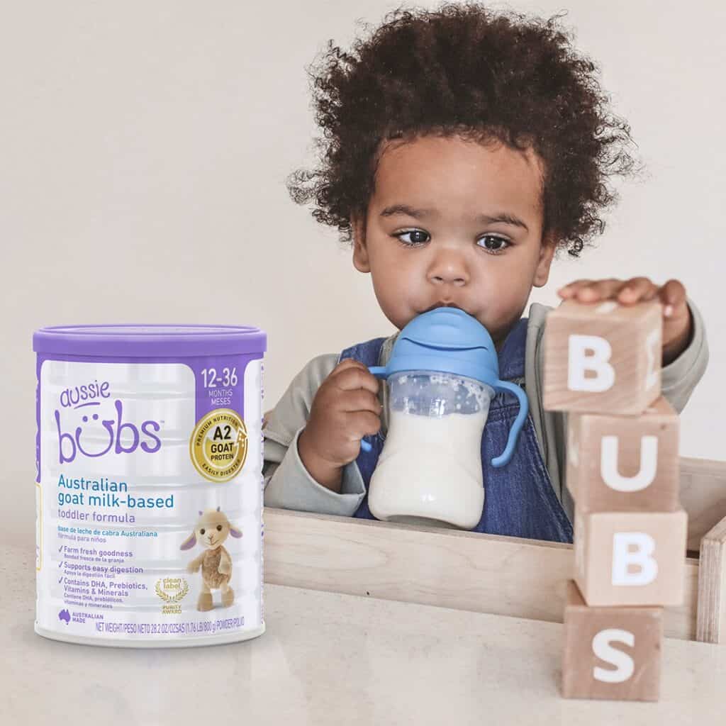 Baby with a can of aussie bubs goat milk formula.