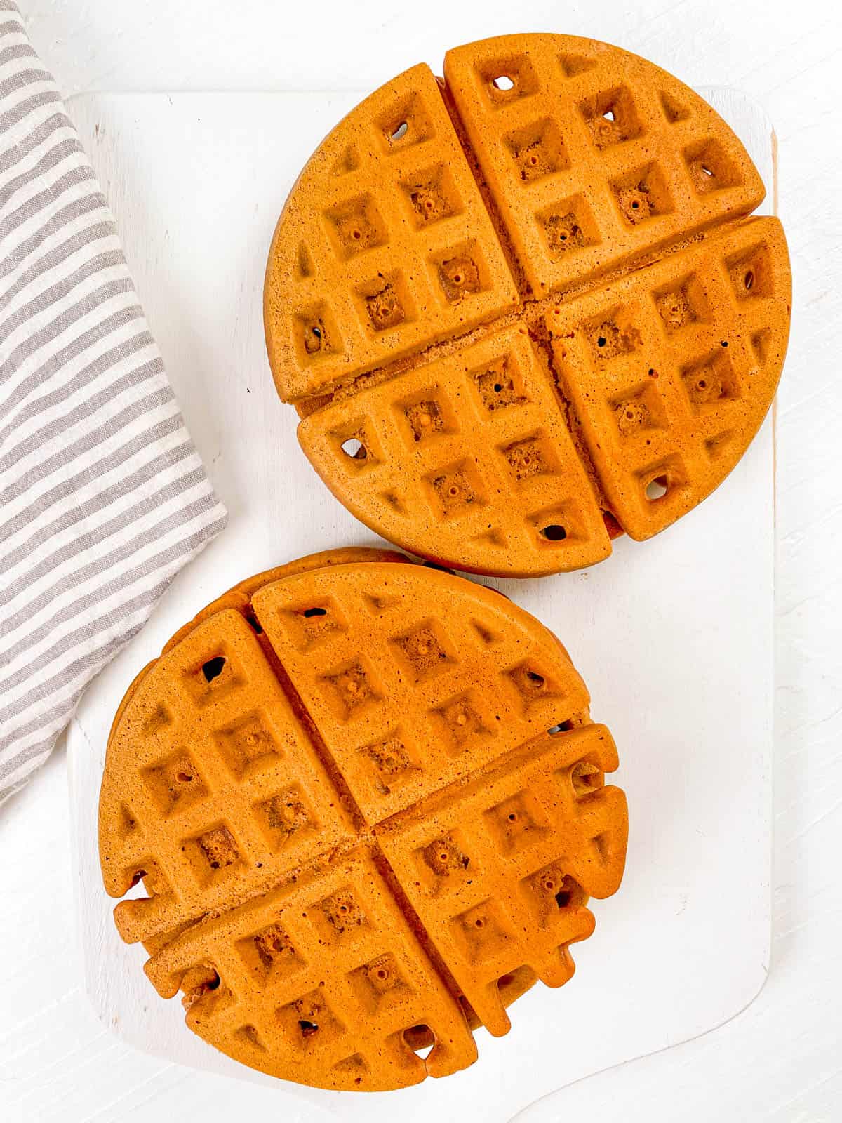 Chocolate nutella waffles cooked and placed on a cutting board.