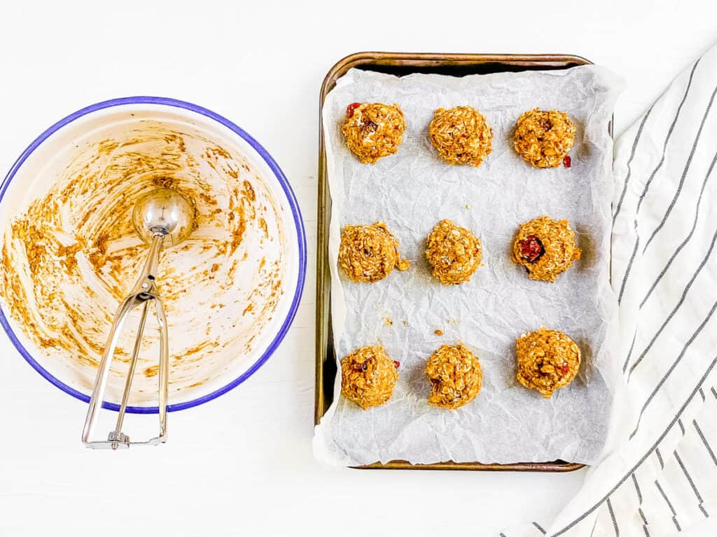 Breakfast cookie dough scooped out onto a baking sheet lined with parchment paper.
