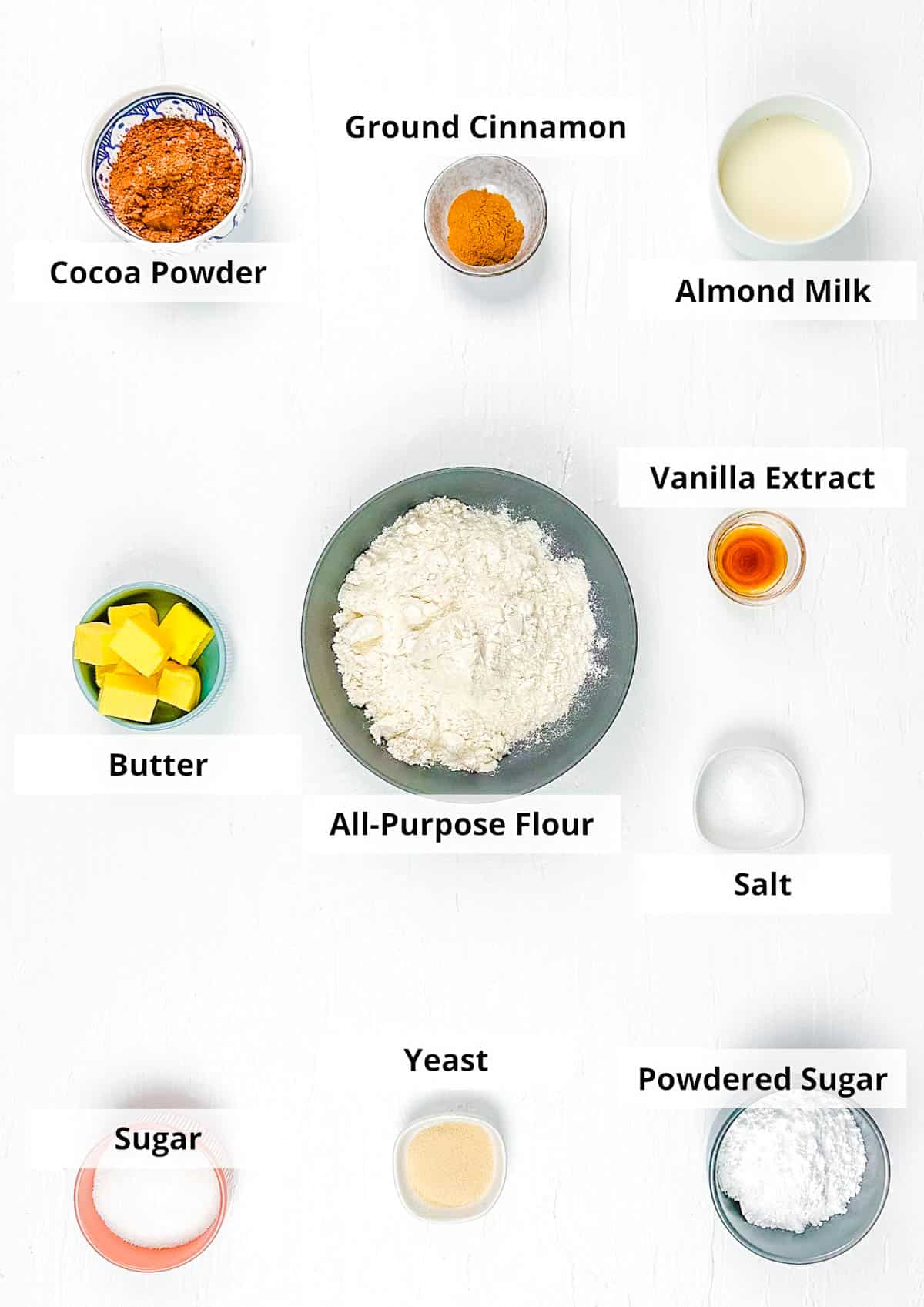 Ingredients for baked eggless donuts recipe on a white background.